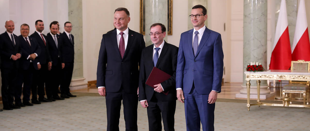 Minister Mariusz Kamiński podczas wspólnego zdjęcia z Prezydentem RP Andrzejem Dudą oraz premierem Mateuszem Morawieckim.